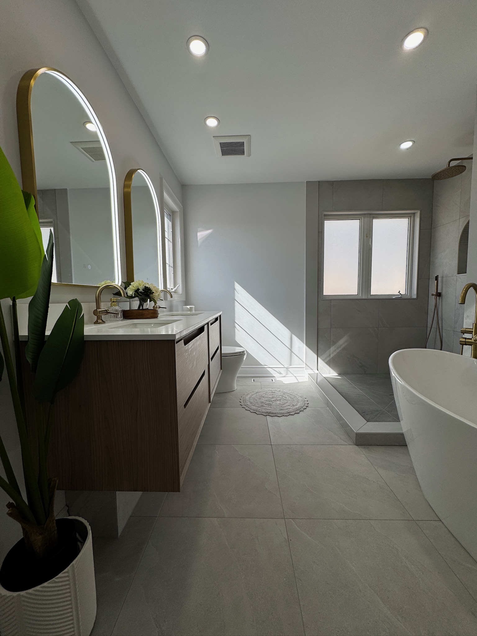 Double vanity, walk-in shower and freestanding tub in a finished bathroom