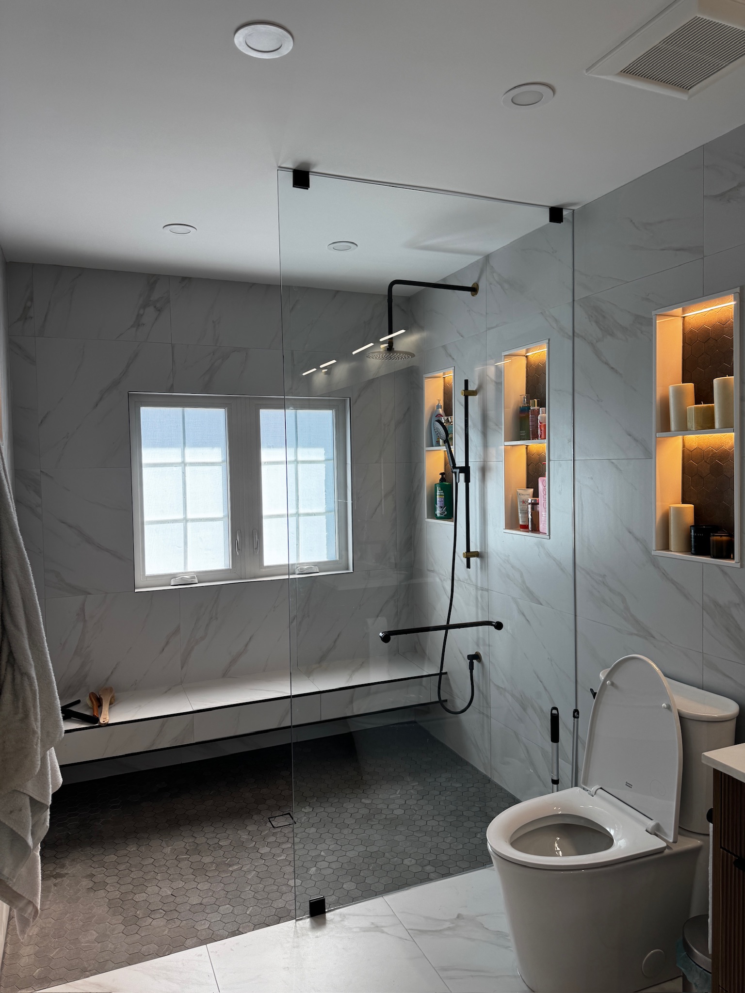 Completed shower with glass enclosure and illuminated niches